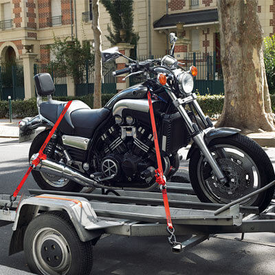 Motorcycle on trailer secured by a tie down strap